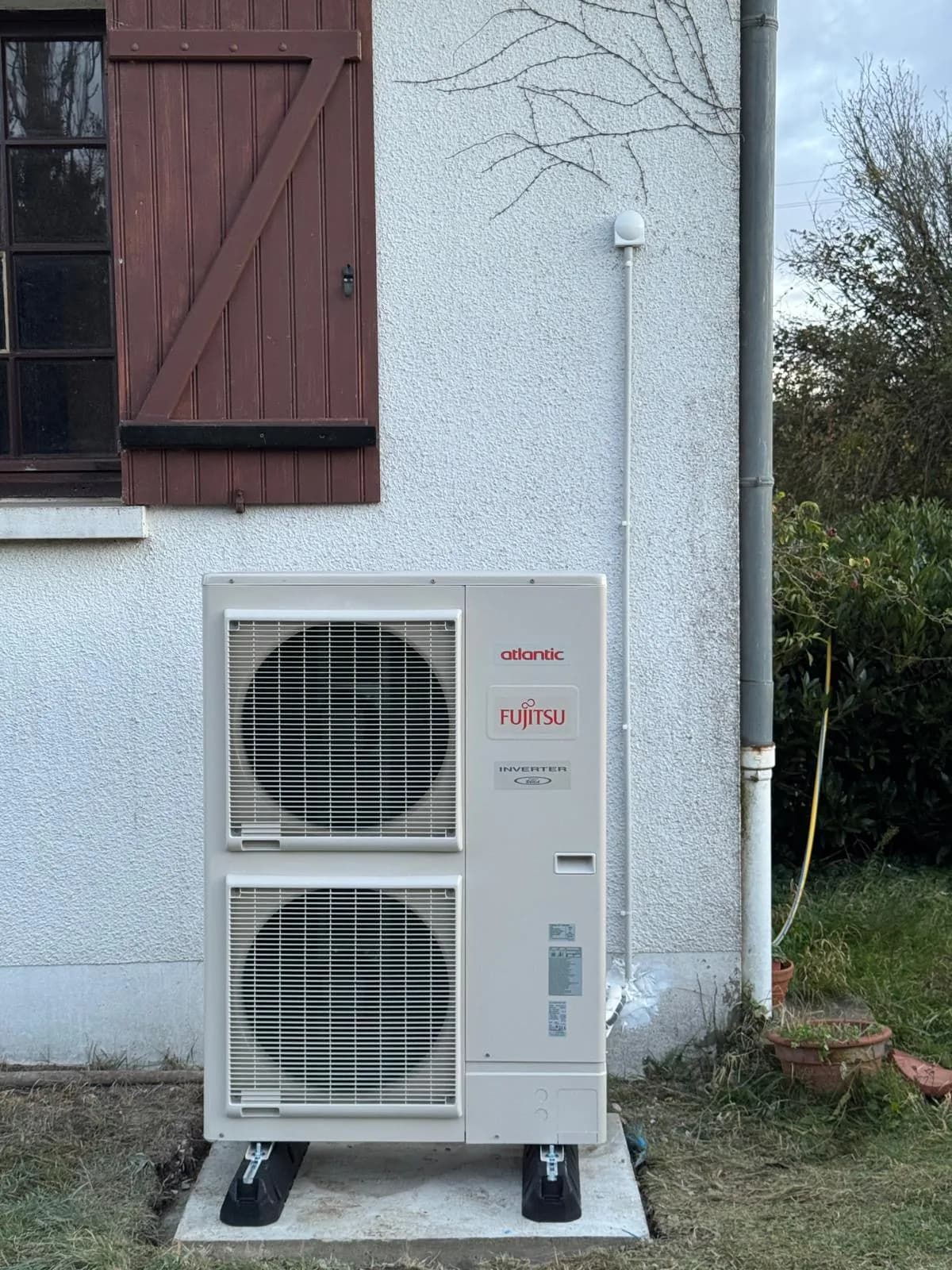 Unité extérieure de pompe à chaleur air-eau Fujitsu posée sur socle béton